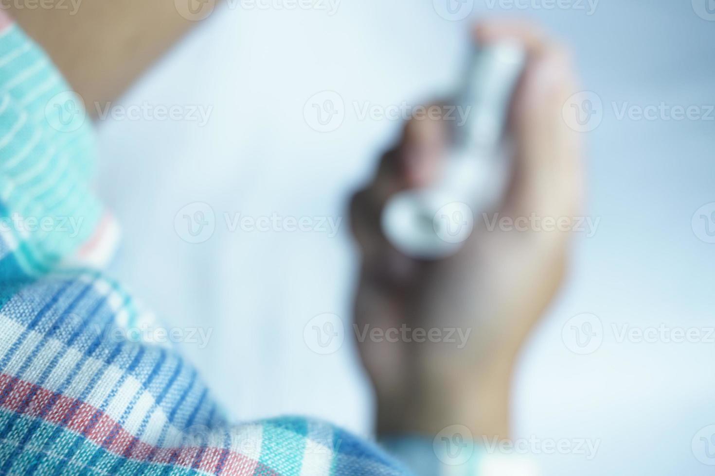 partially blurred picture of man holding asthma inhaler. Medical equipment photo