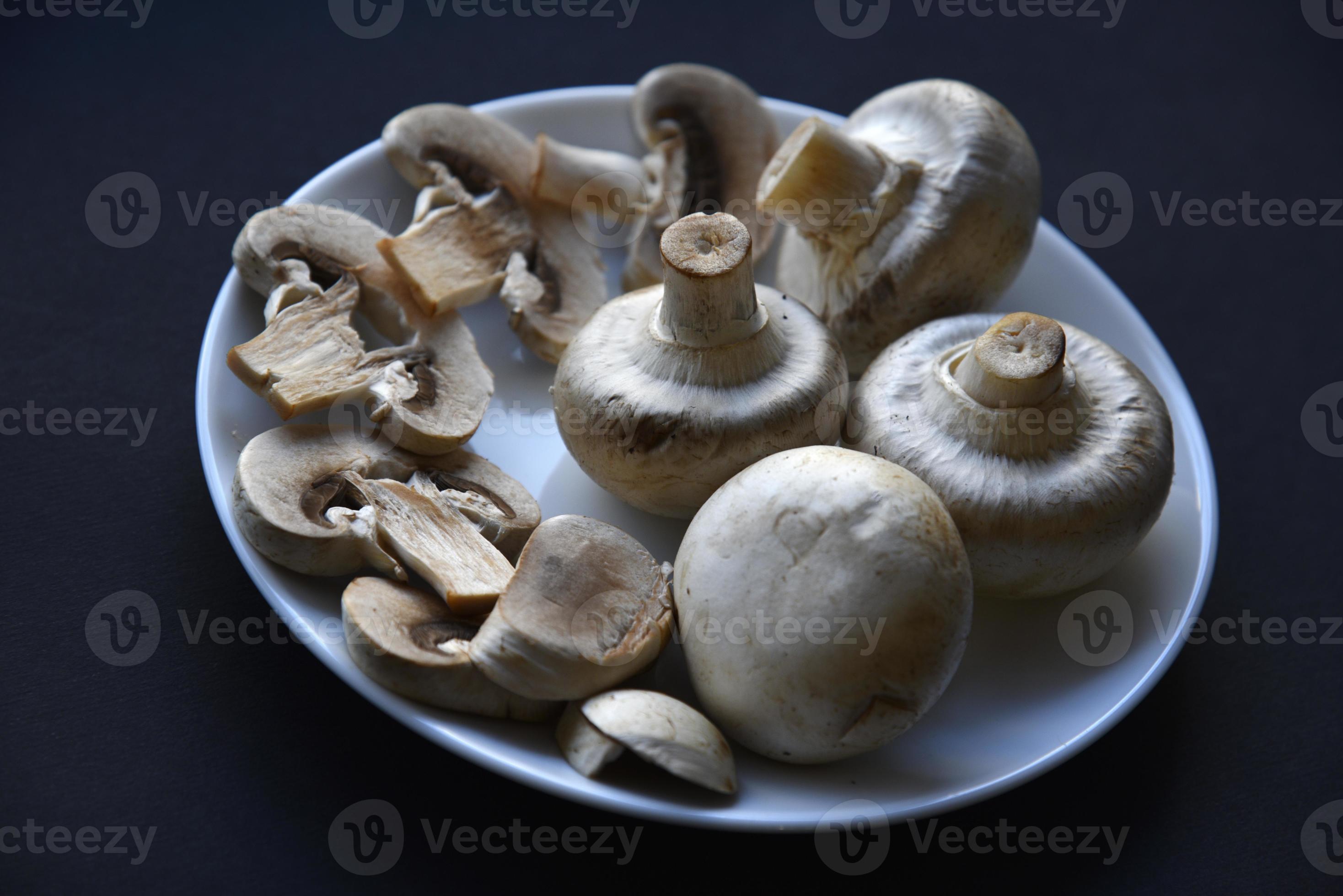 Porcini mushrooms in a white plate on a black background. Fruits of