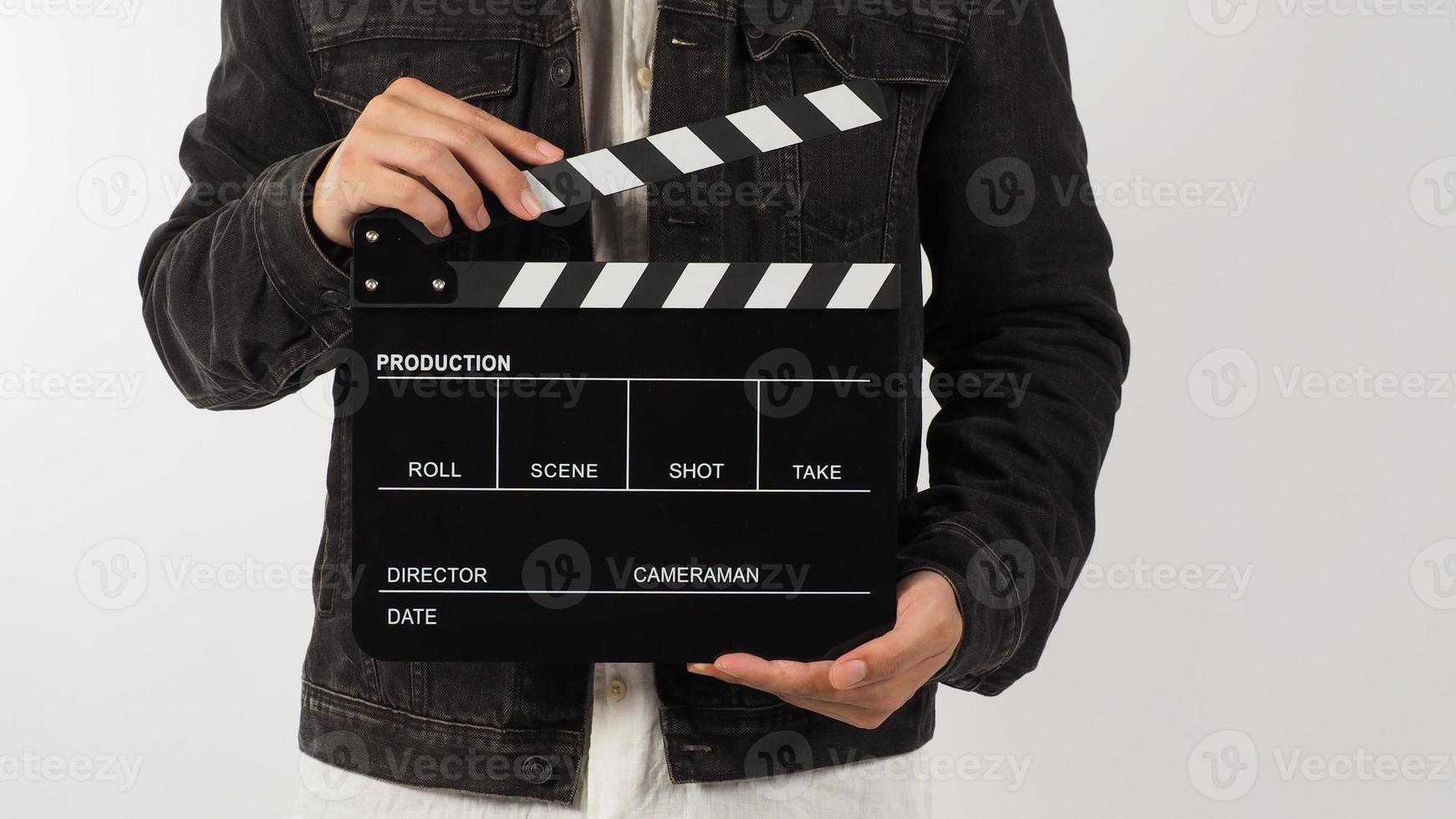 Body part of a man is holding black clapperboard or movie slate on white background. Studio shooting photo