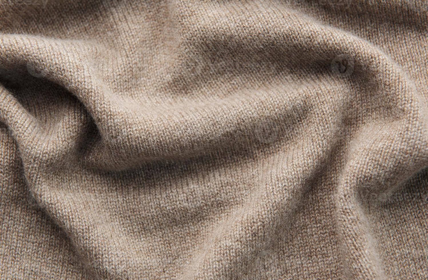 Warm cashmere fabric as background, top view photo