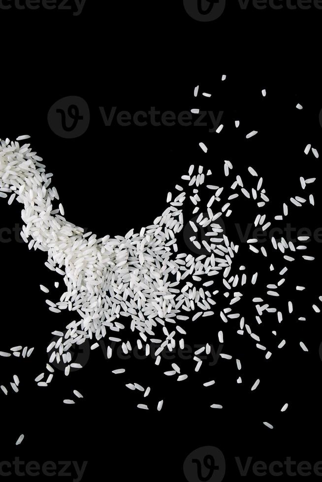 Raw white rice splash on black background. Uncooked rice explosion. photo