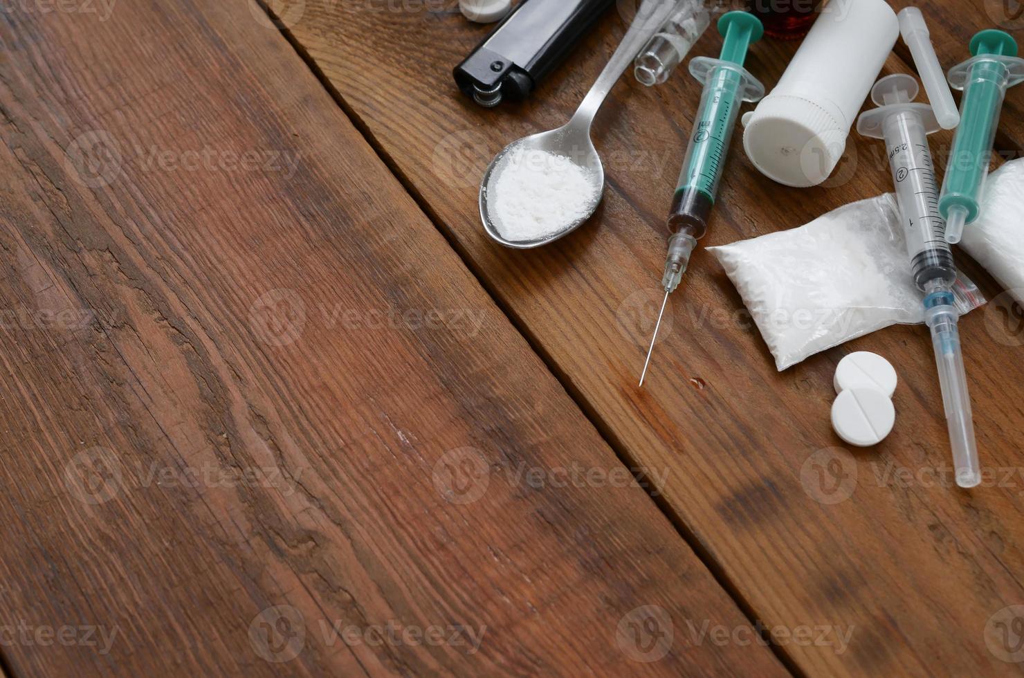 A lot of narcotic substances and devices for the preparation of drugs lie on an old wooden table photo