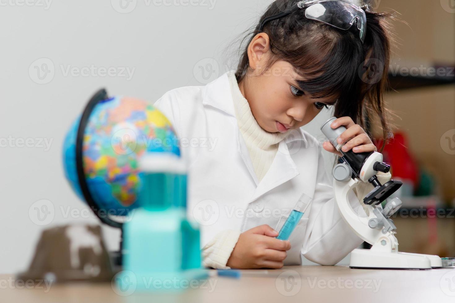 education, science, chemistry and children concept - kids or students with test tube making experiment at school laboratory photo