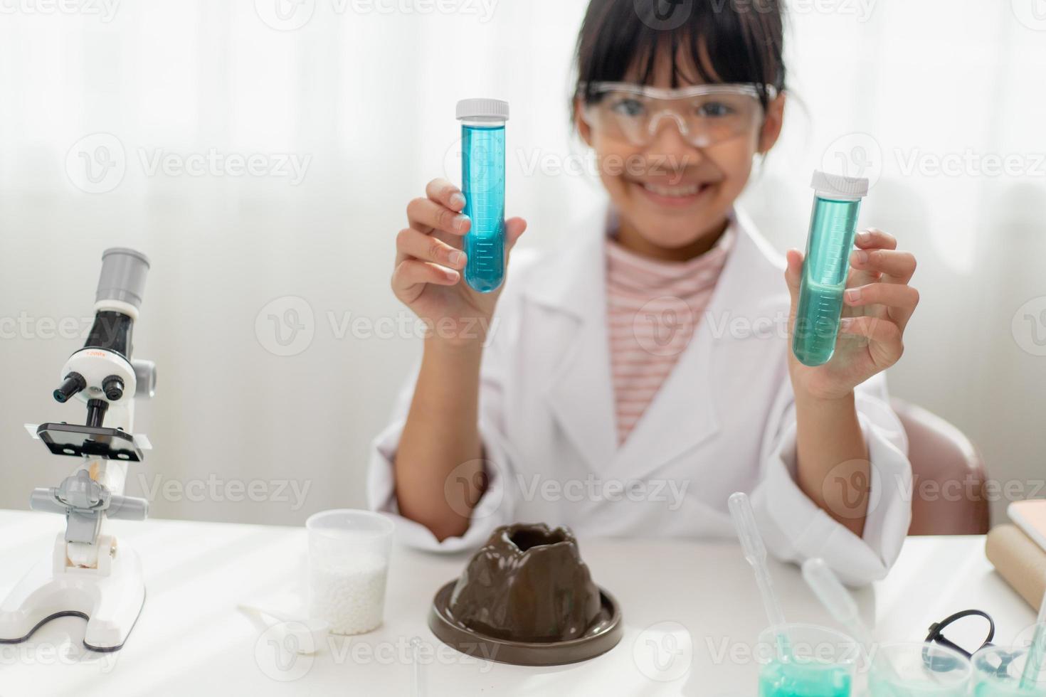 education, science, chemistry and children concept - kids or students with test tube making experiment at school laboratory photo