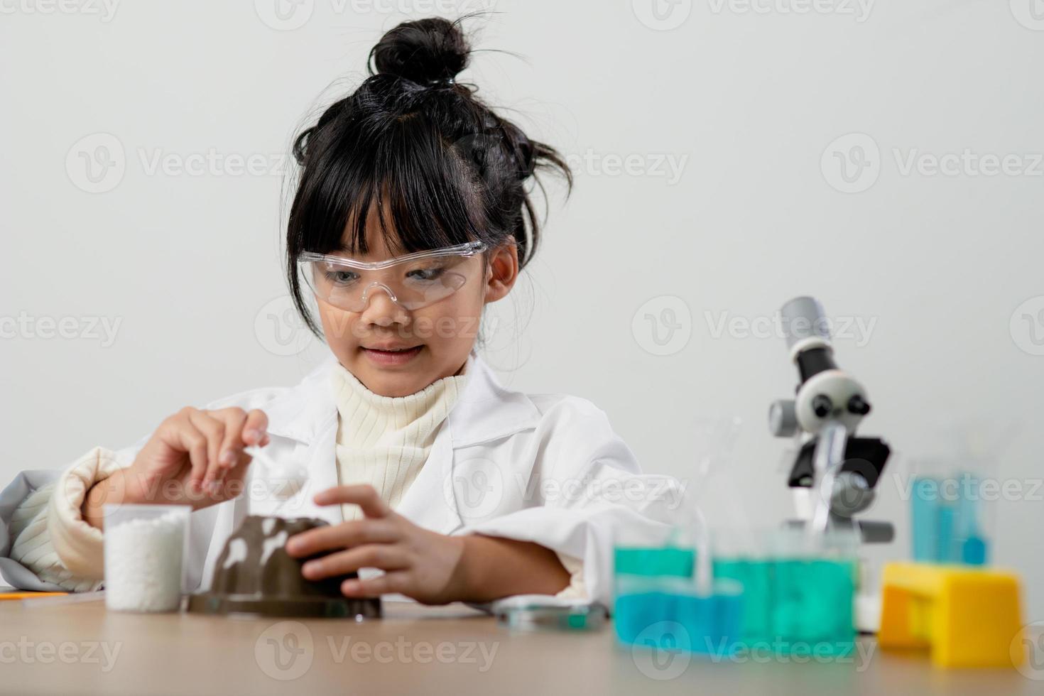 education, science, chemistry and children concept - kids or students with test tube making experiment at school laboratory photo