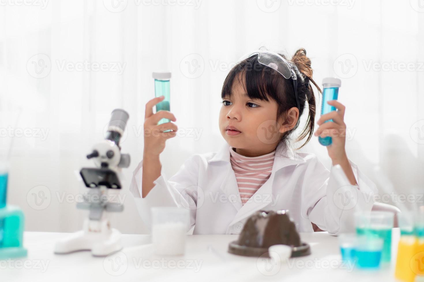 education, science, chemistry and children concept - kids or students with test tube making experiment at school laboratory photo