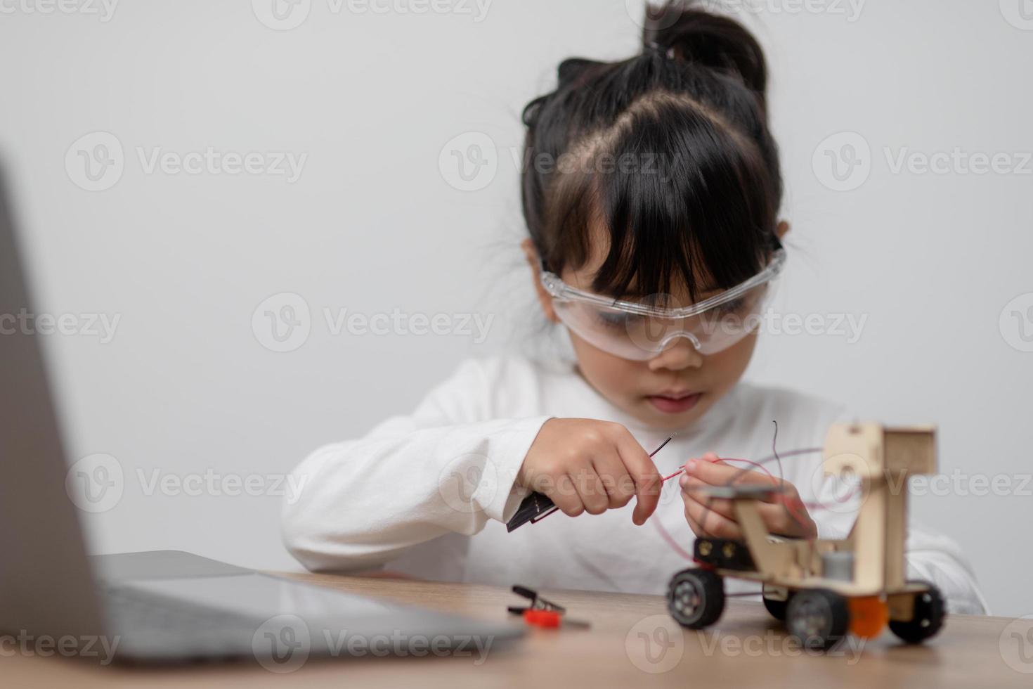 los estudiantes de asia aprenden en casa a codificar autos robot y cables de tableros electrónicos en tallo, vapor, ingeniería matemática, ciencia, tecnología, código de computadora en robótica para el concepto de niños. foto