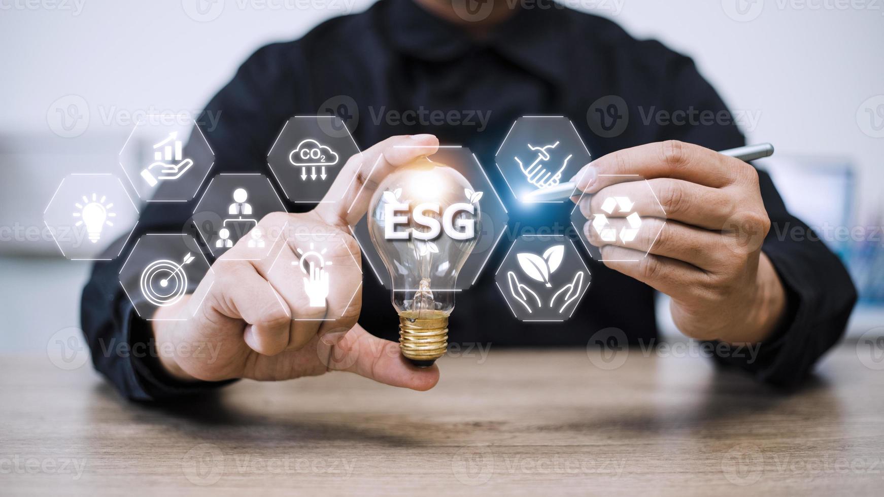 Businessman hand holding light bulb with esg icon on virtual screen, ESG Environmental, social and corporate governance concept photo