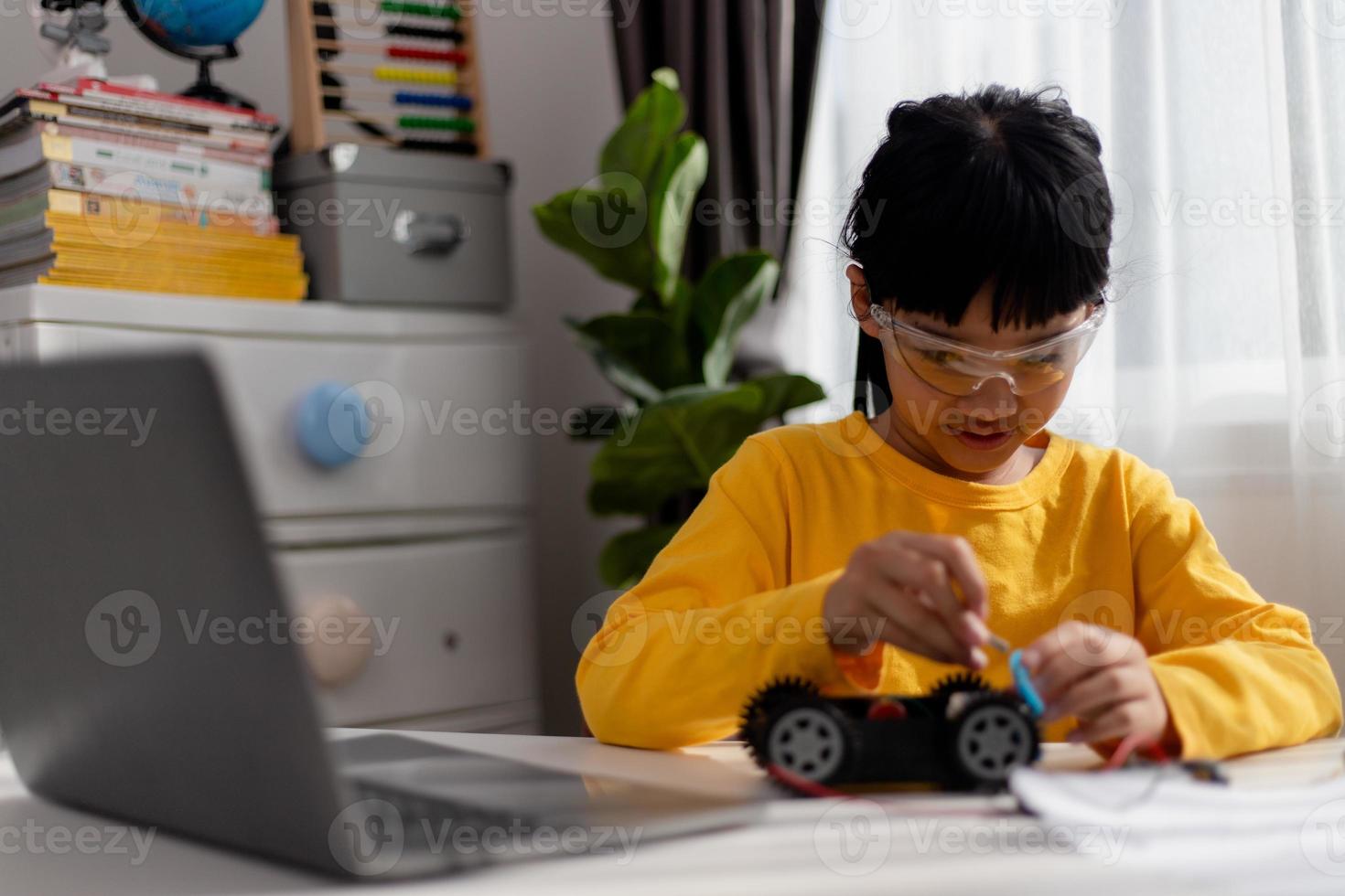 Asia students learn at home in coding robot cars and electronic board cables in STEM, STEAM, mathematics engineering science technology computer code in robotics for kids concept. photo