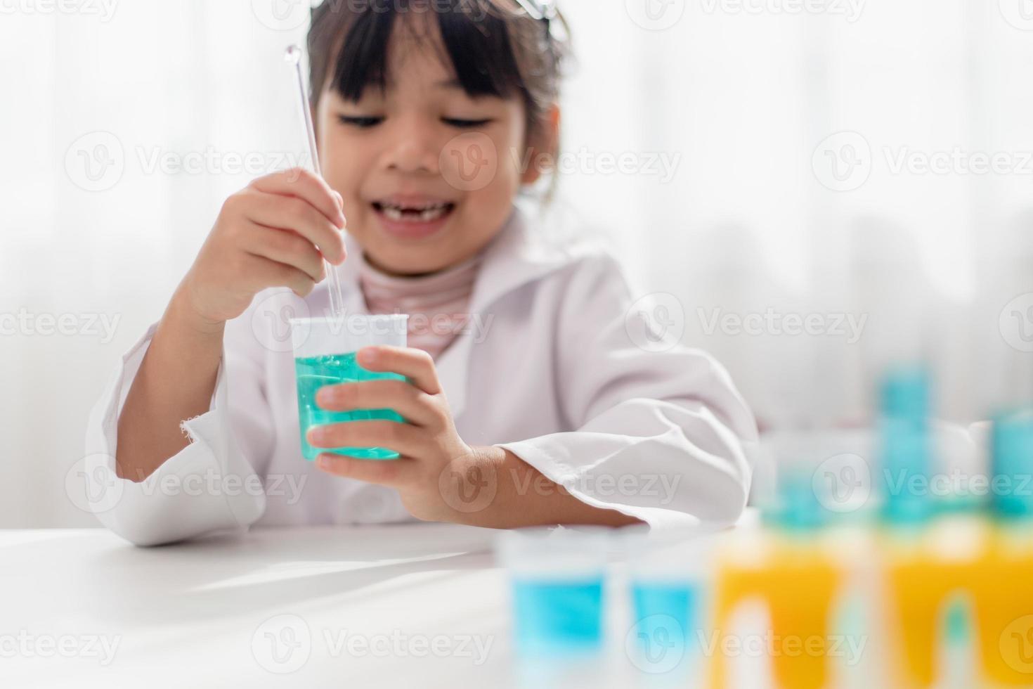 education, science, chemistry and children concept - kids or students with test tube making experiment at school laboratory photo