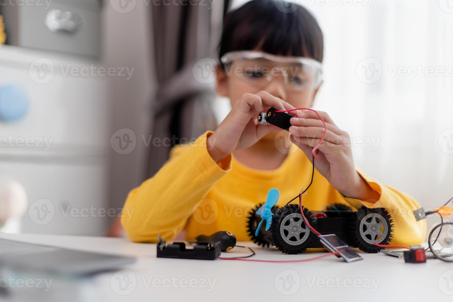 Asia students learn at home in coding robot cars and electronic board cables in STEM, STEAM, mathematics engineering science technology computer code in robotics for kids concept. photo