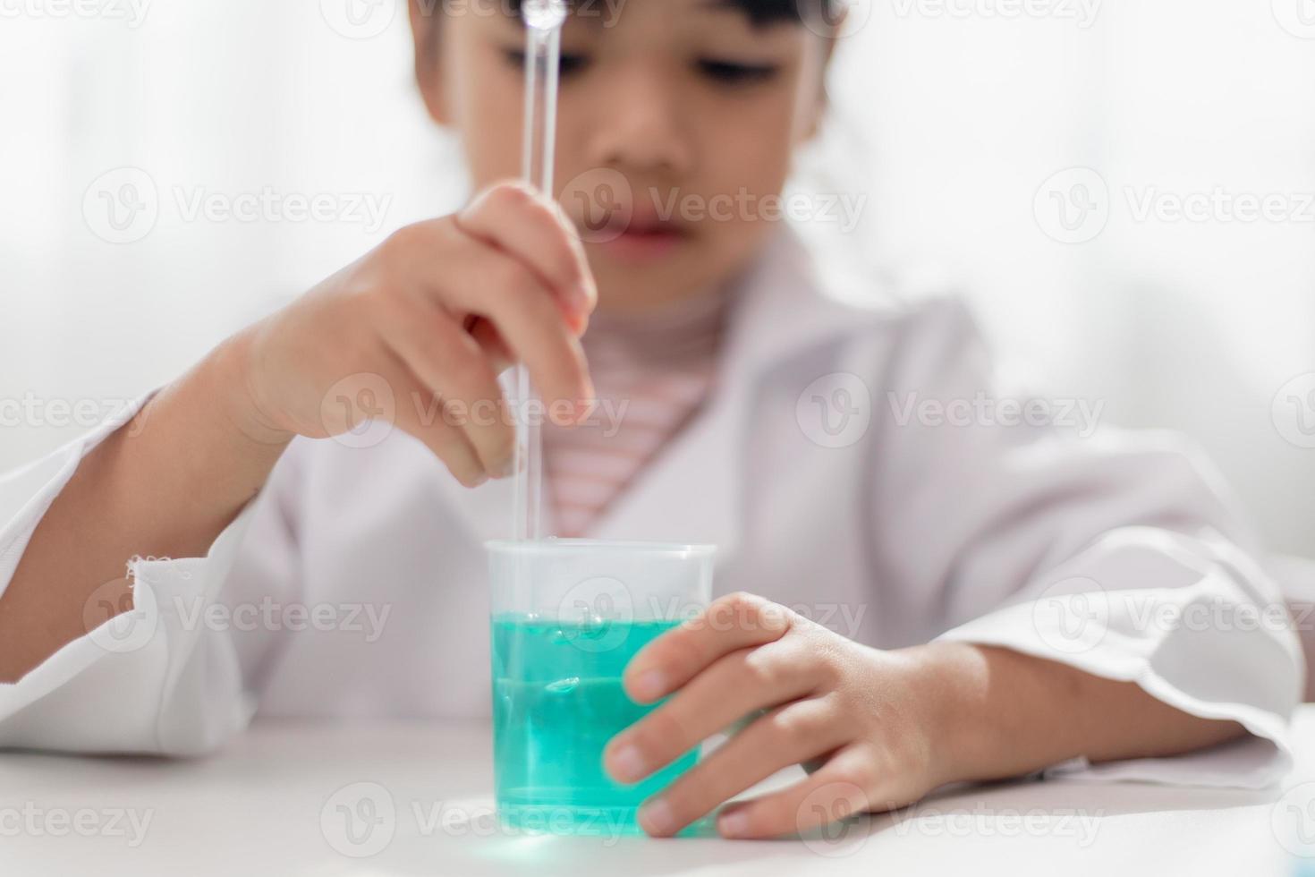 education, science, chemistry and children concept - kids or students with test tube making experiment at school laboratory photo