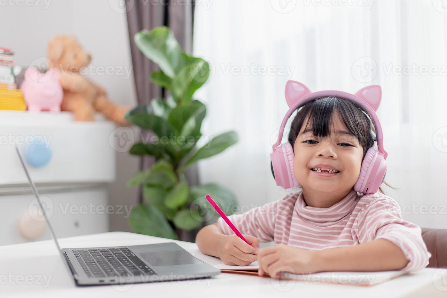 Asian little girl in headphones have video call distant class with teacher using laptop, study online on computer, homeschooling concept photo