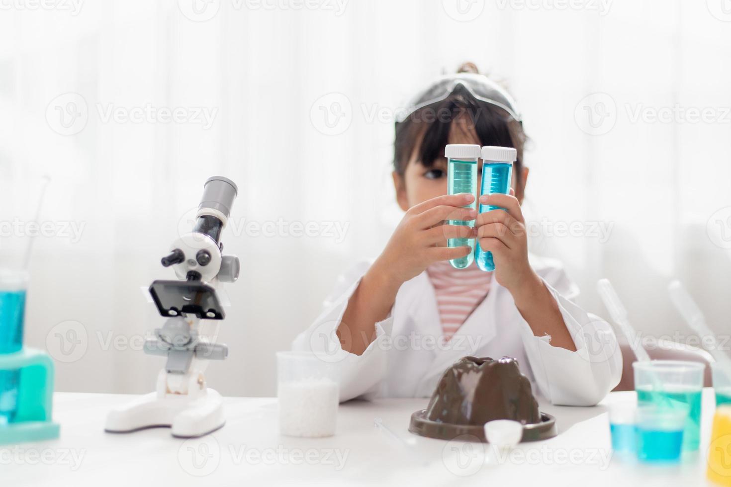 education, science, chemistry and children concept - kids or students with test tube making experiment at school laboratory photo