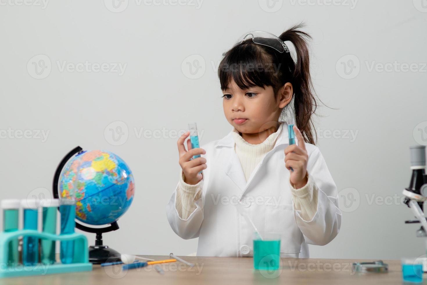 education, science, chemistry and children concept - kids or students with test tube making experiment at school laboratory photo