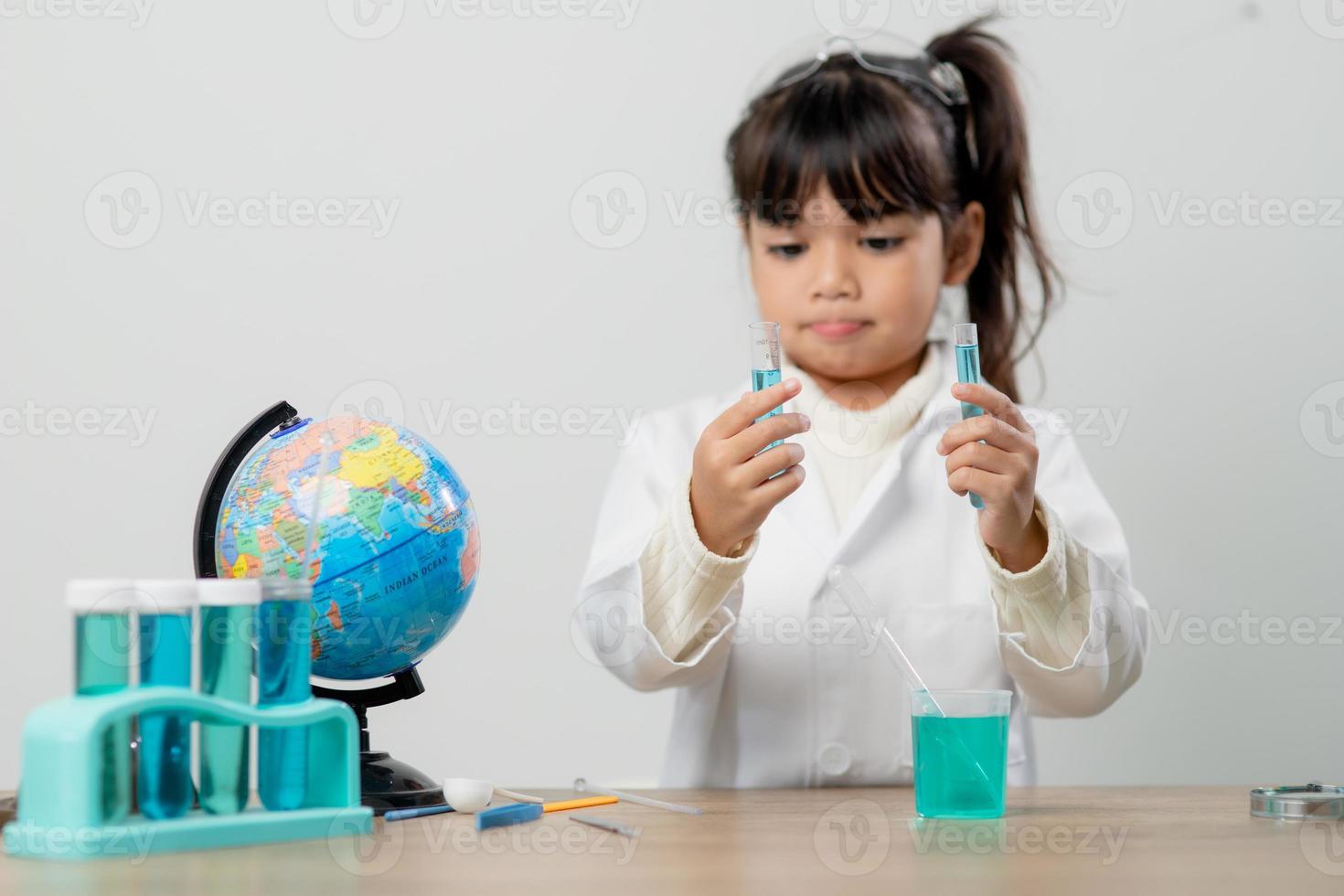 education, science, chemistry and children concept - kids or students with test tube making experiment at school laboratory photo