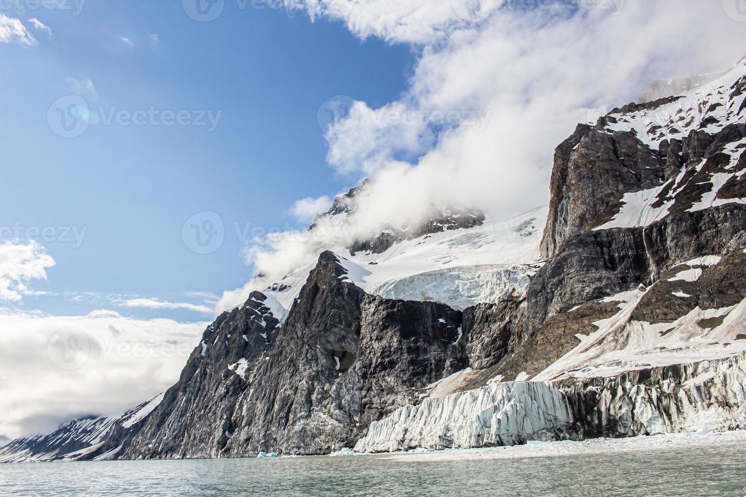 un glaciar con montañas nevadas detrás en svalbard foto