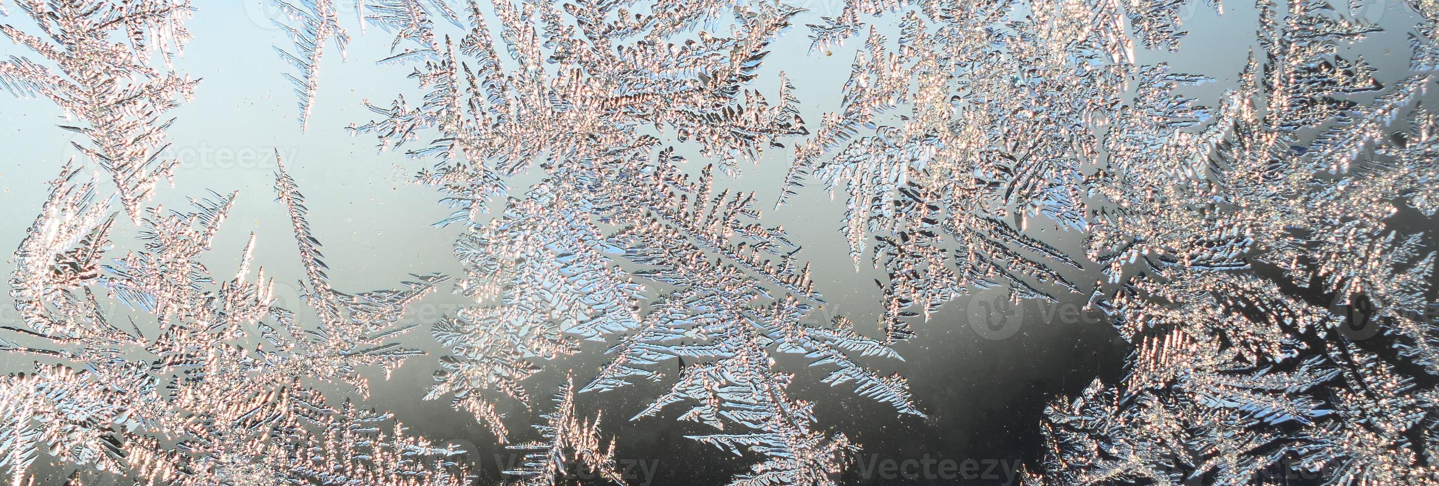 Snowflakes frost rime macro on window glass pane photo