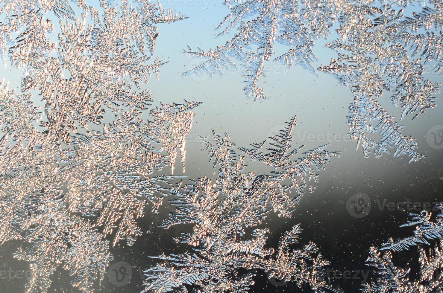 Snowflakes frost rime macro on window glass pane photo