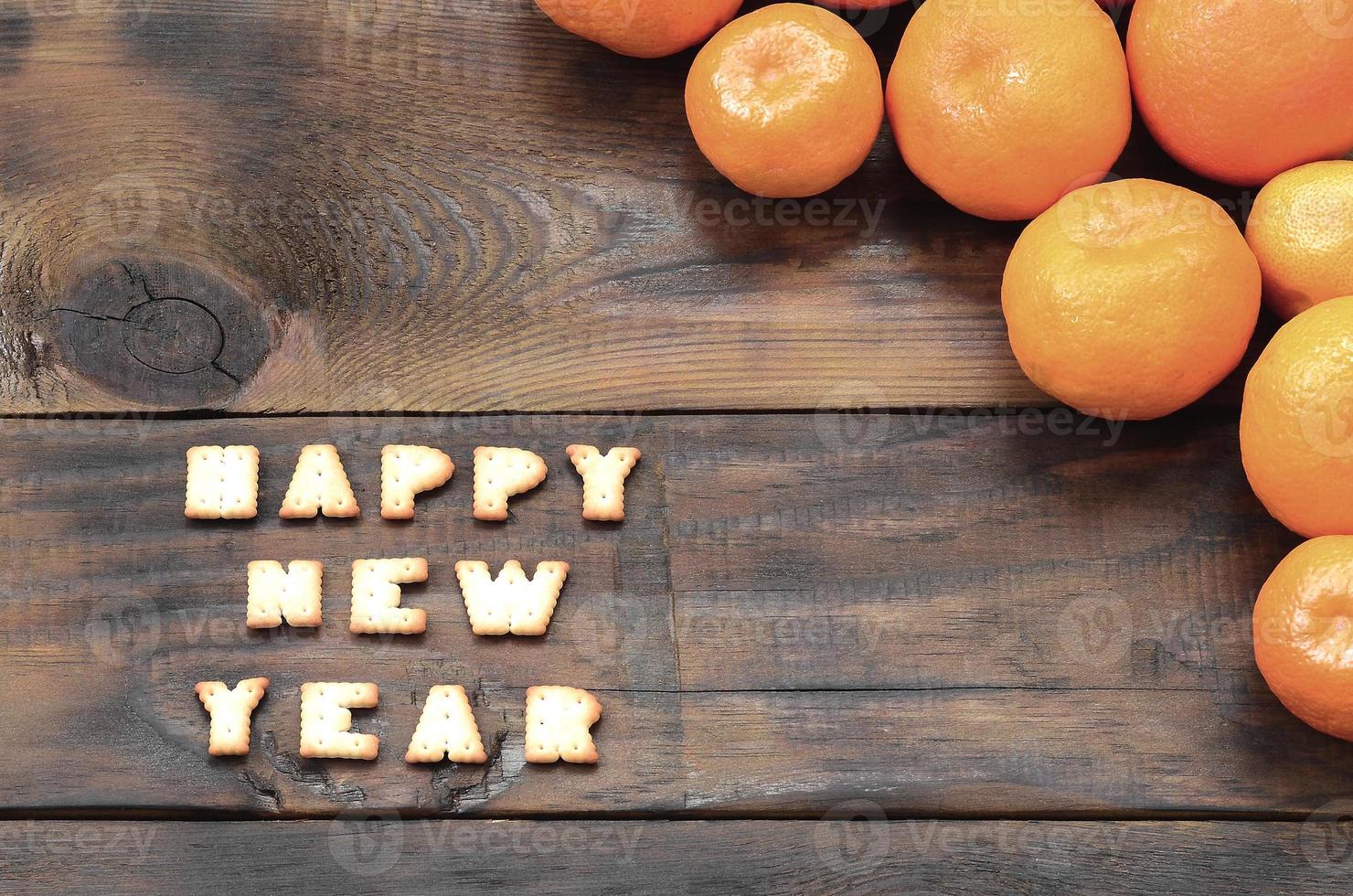 Tangerines, cracker text with copy space on wooden background photo