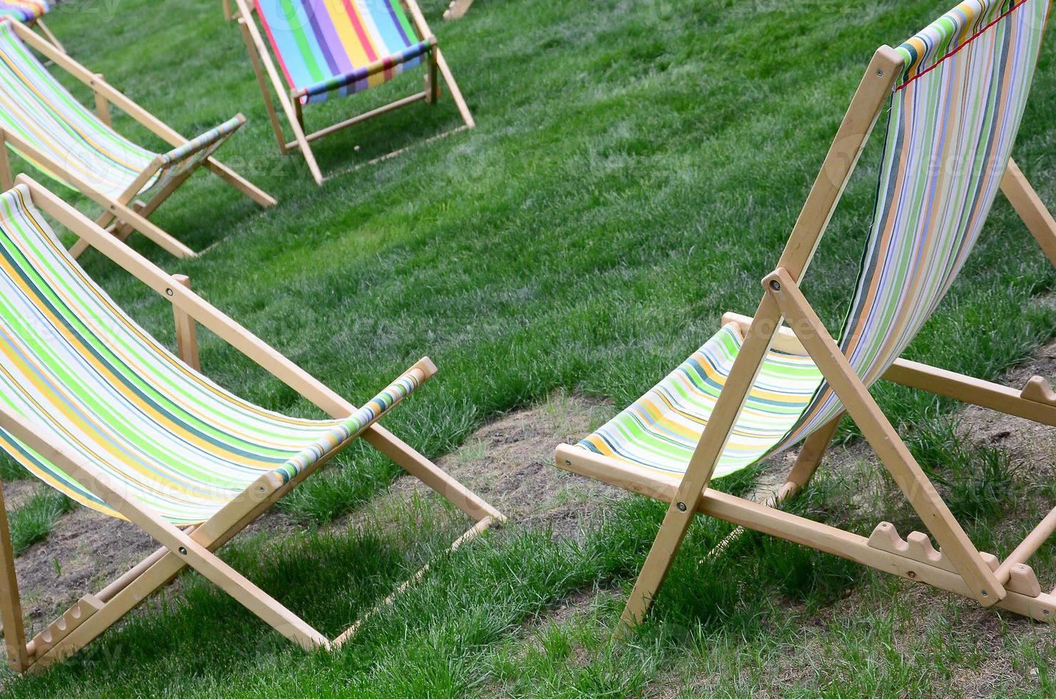 Chaise lounges on a lawn. Garden sunbeds on green grass photo