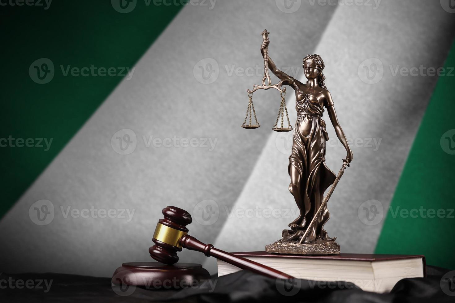 Nigeria flag with statue of lady justice, constitution and judge hammer on black drapery. Concept of judgement and guilt photo