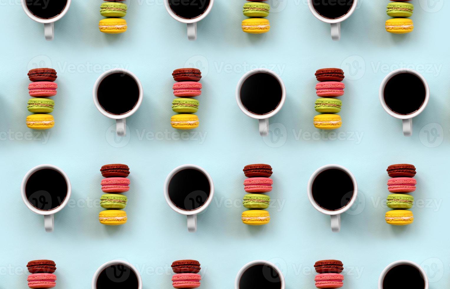 A pattern of many colorful dessert cake macaroon and coffee cups on trendy pastel blue background top view. Flat lay composition photo