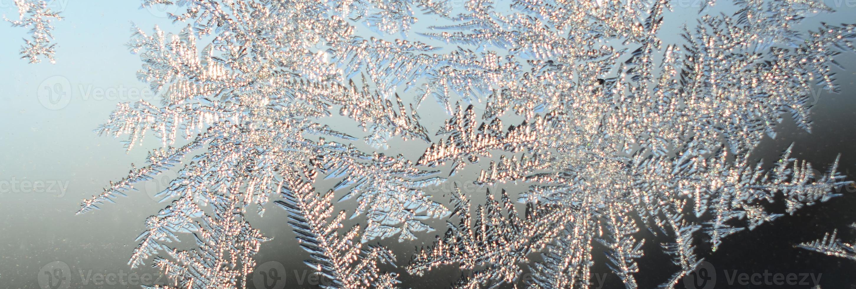 Snowflakes frost rime macro on window glass pane photo