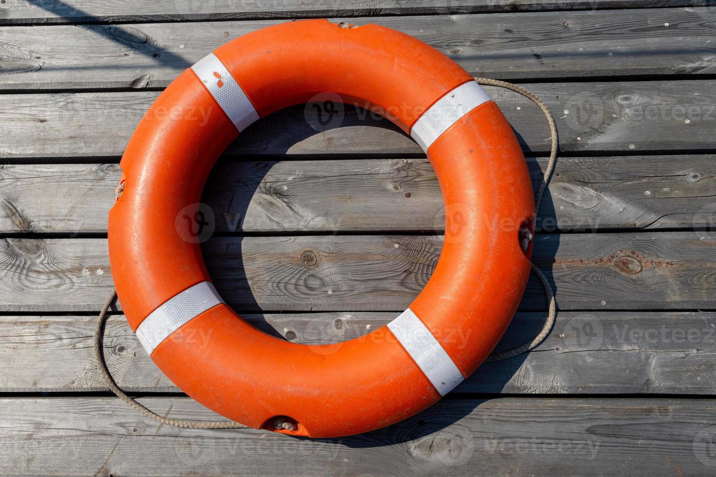 The lifebuoy is lying on a wooden pier. The concept of saving drowning photo