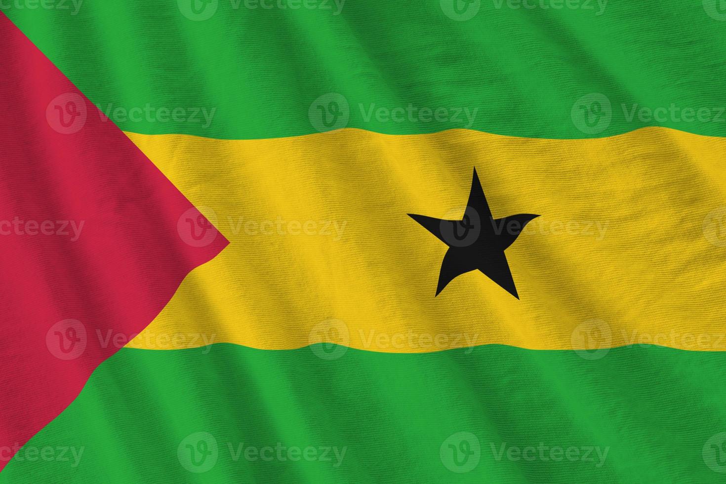 Sao Tome and Principe flag with big folds waving close up under the studio light indoors. The official symbols and colors in banner photo
