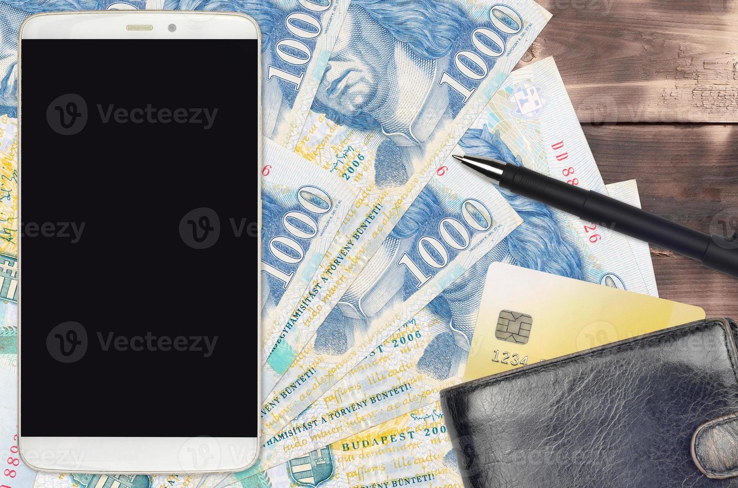 1000 Hungarian forint bills and smartphone with purse and credit card. E-payments or e-commerce concept. Online shopping and business with portable devices photo