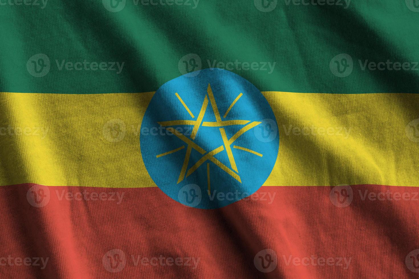 Ethiopia flag with big folds waving close up under the studio light indoors. The official symbols and colors in banner photo