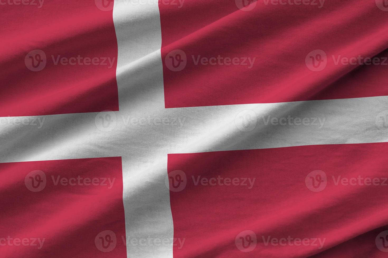 Denmark flag with big folds waving close up under the studio light indoors. The official symbols and colors in banner photo