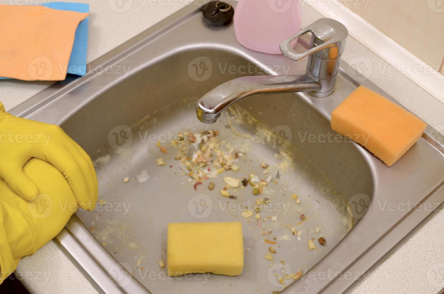The housekeeper was faced with the problem of washing an overly dirty sink filled with food particles photo