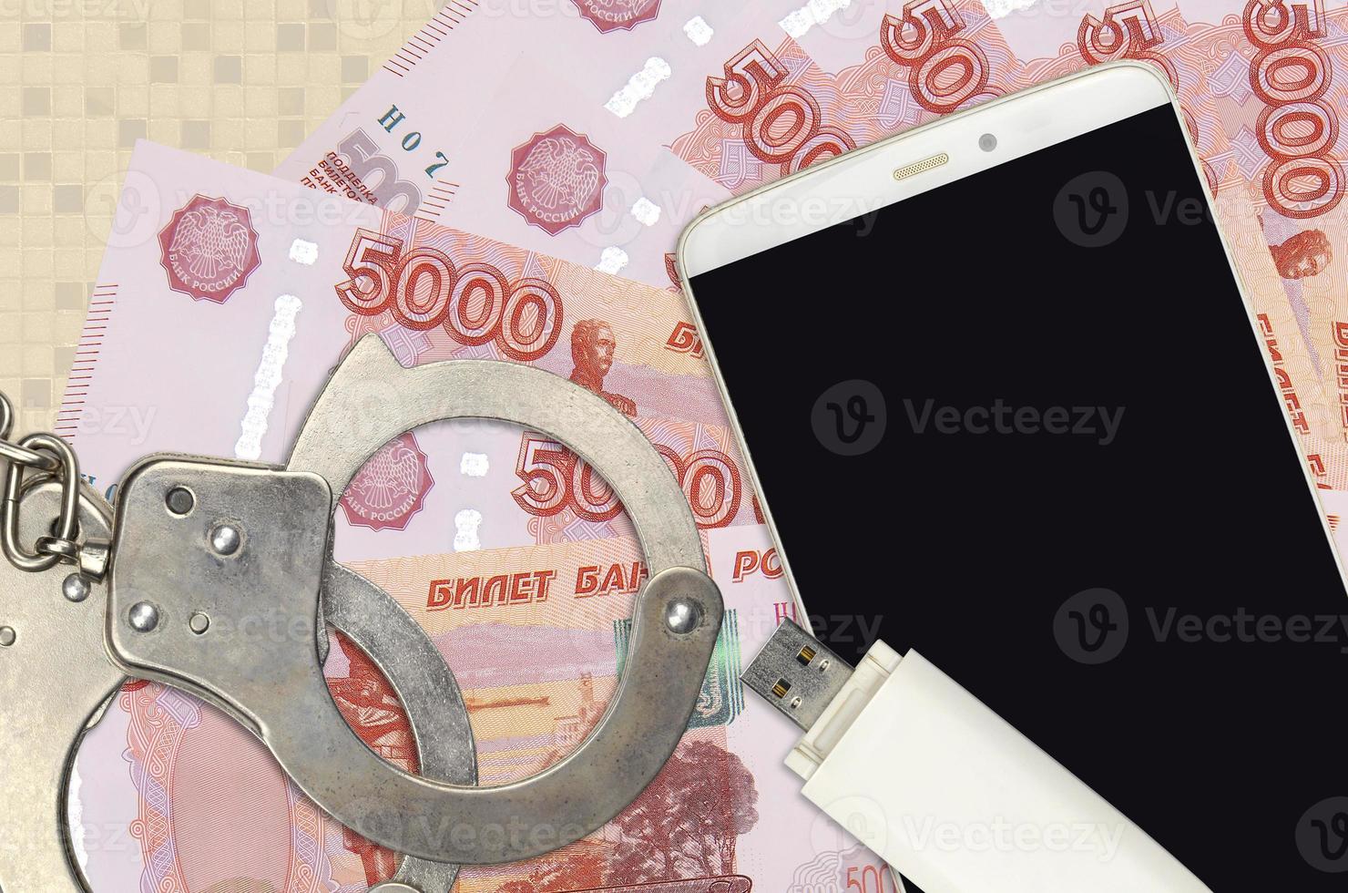 5000 russian rubles bills and smartphone with police handcuffs. Concept of hackers phishing attacks, illegal scam or malware soft distribution photo