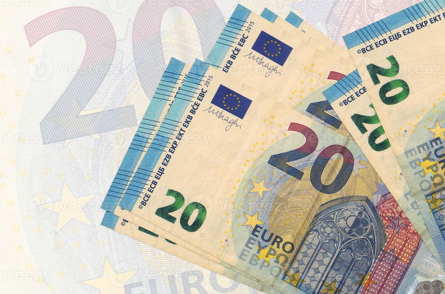 20 euro bills lies in stack on background of big semi-transparent banknote. Abstract presentation of national currency photo