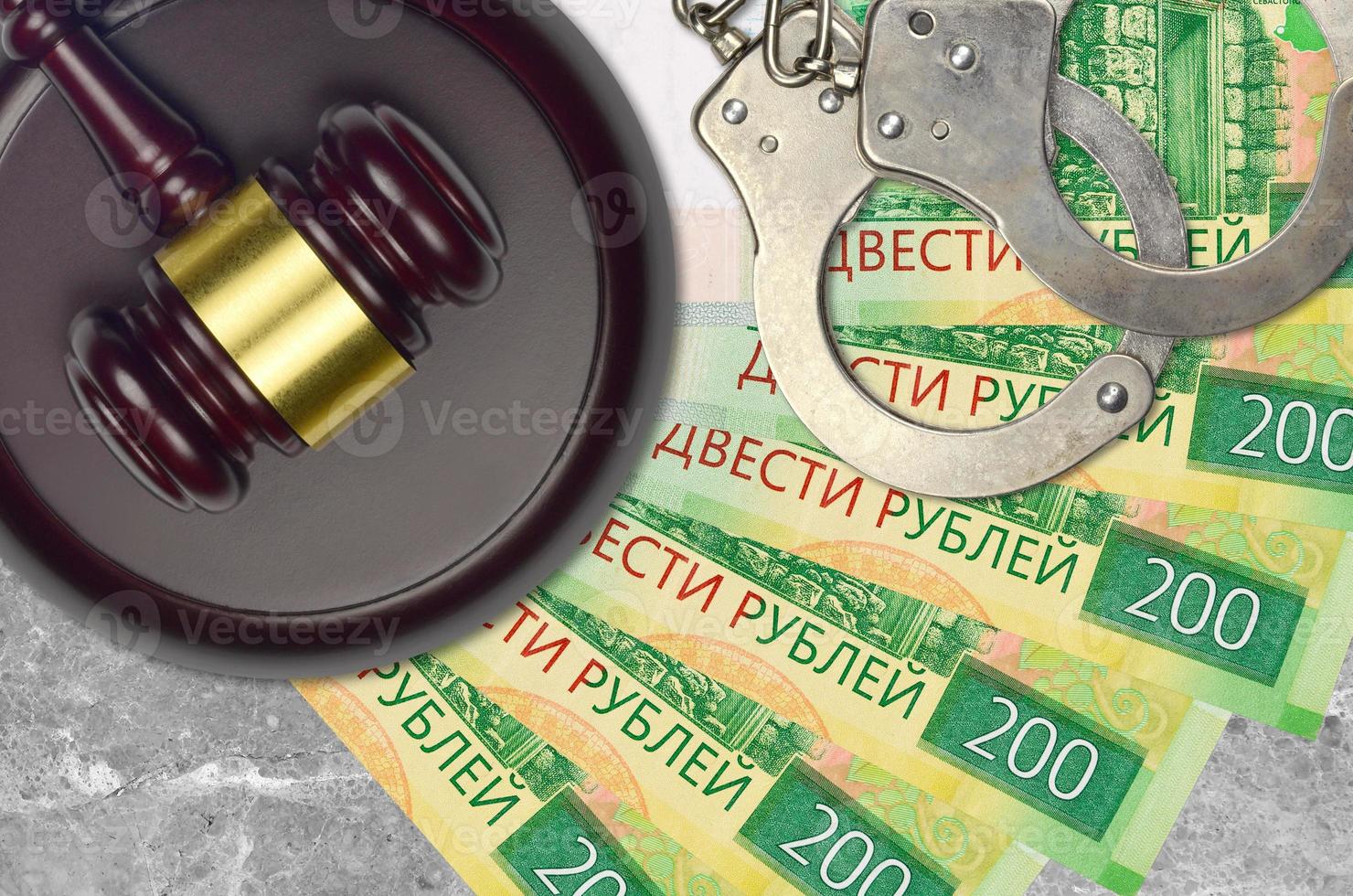 200 russian rubles bills and judge hammer with police handcuffs on court desk. Concept of judicial trial or bribery. Tax avoidance photo