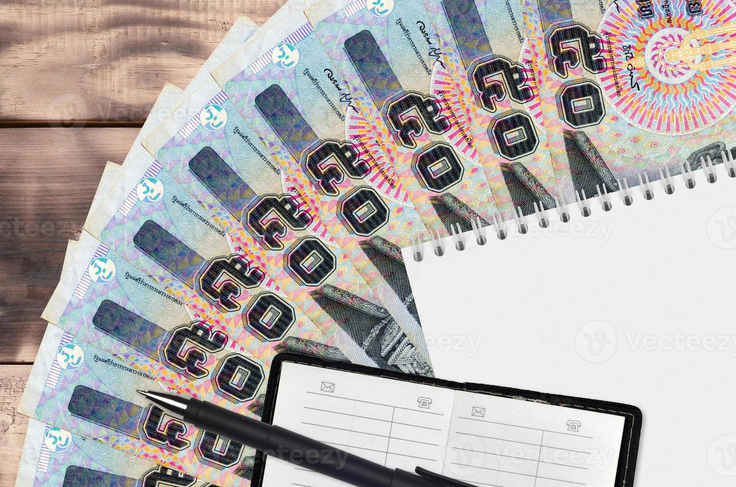 50 Thai Baht bills fan and notepad with contact book and black pen. Concept of financial planning and business strategy photo