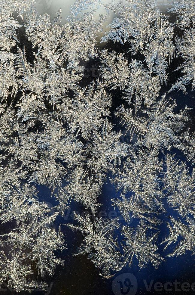 Snowflakes frost rime macro on window glass pane photo
