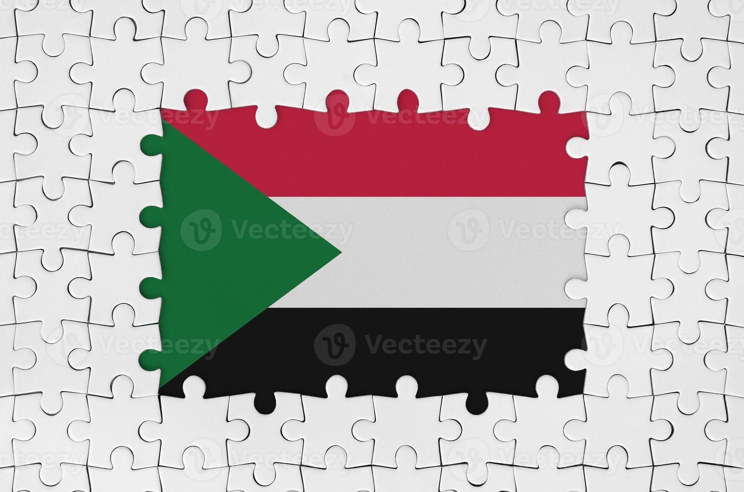 Sudan flag in frame of white puzzle pieces with missing central part photo