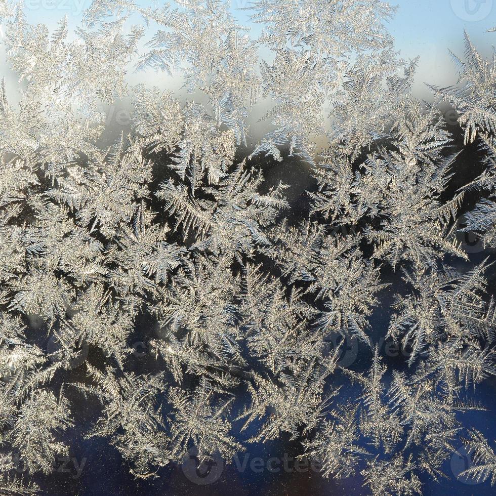 Snowflakes frost rime macro on window glass pane photo