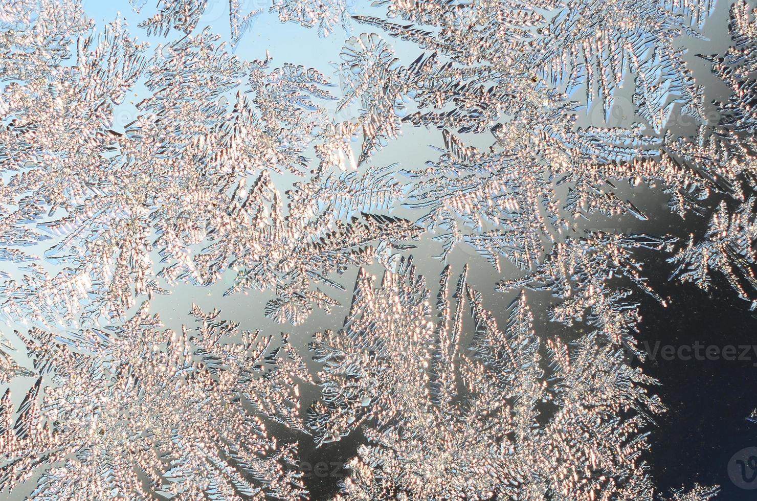 Snowflakes frost rime macro on window glass pane photo