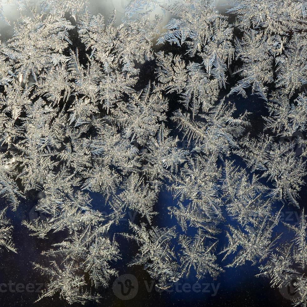 copos de nieve escarcha escarcha macro en el cristal de la ventana foto