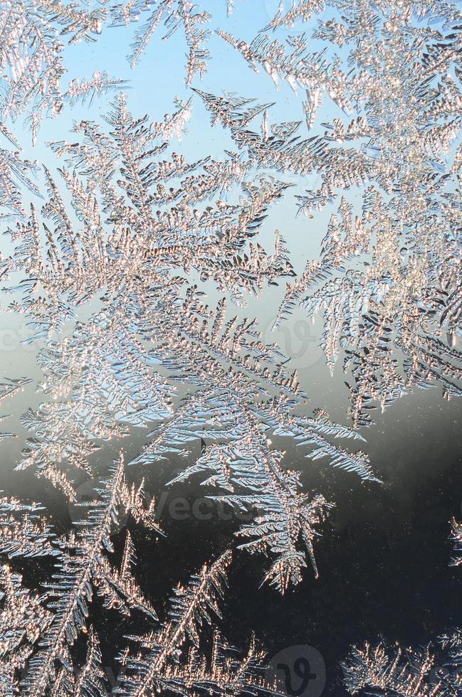 Snowflakes frost rime macro on window glass pane photo