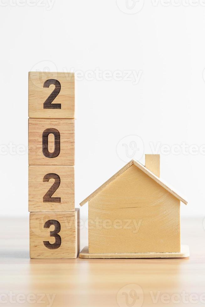 Bloque 2023 con casa modelo. conceptos de resolución de bienes raíces, préstamos hipotecarios, impuestos, inversiones, finanzas, ahorros y año nuevo foto