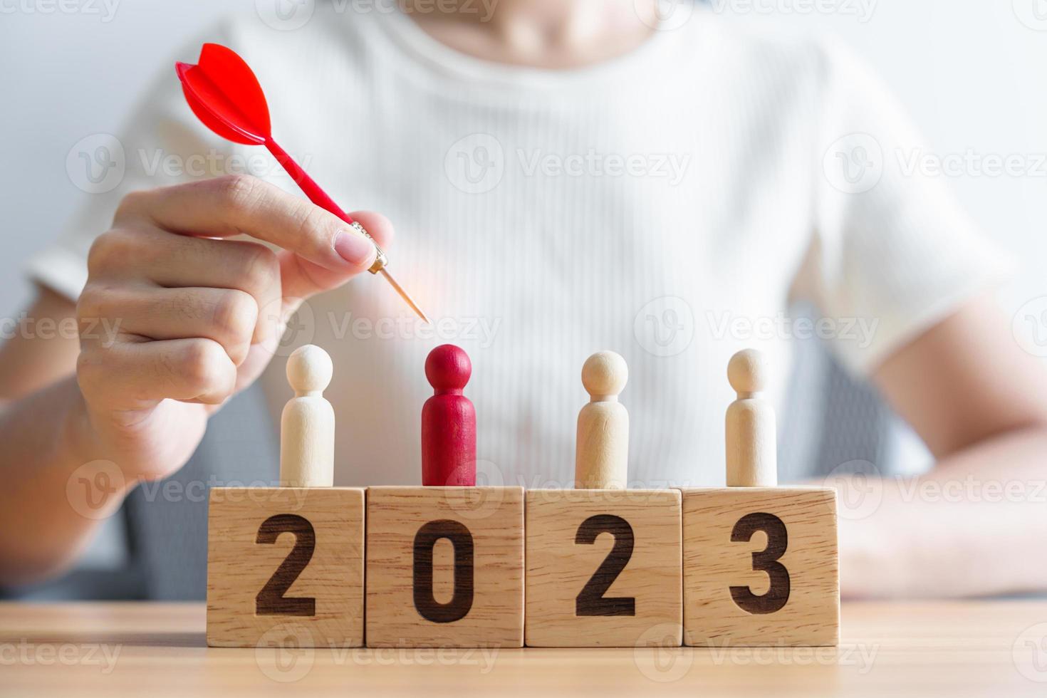 dardo de mano sobre personas rojas y bloques de 2023 años.objetivo, plan, acción, objetivo, estrategia, liderazgo, año nuevo y concepto de marketing foto