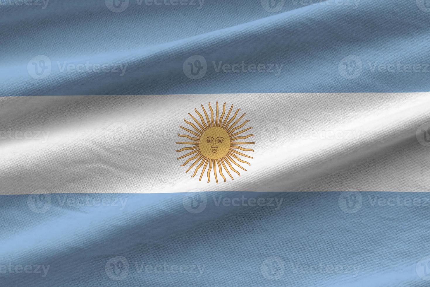 bandera argentina con grandes pliegues ondeando de cerca bajo la luz del estudio en el interior. los símbolos y colores oficiales en banner foto