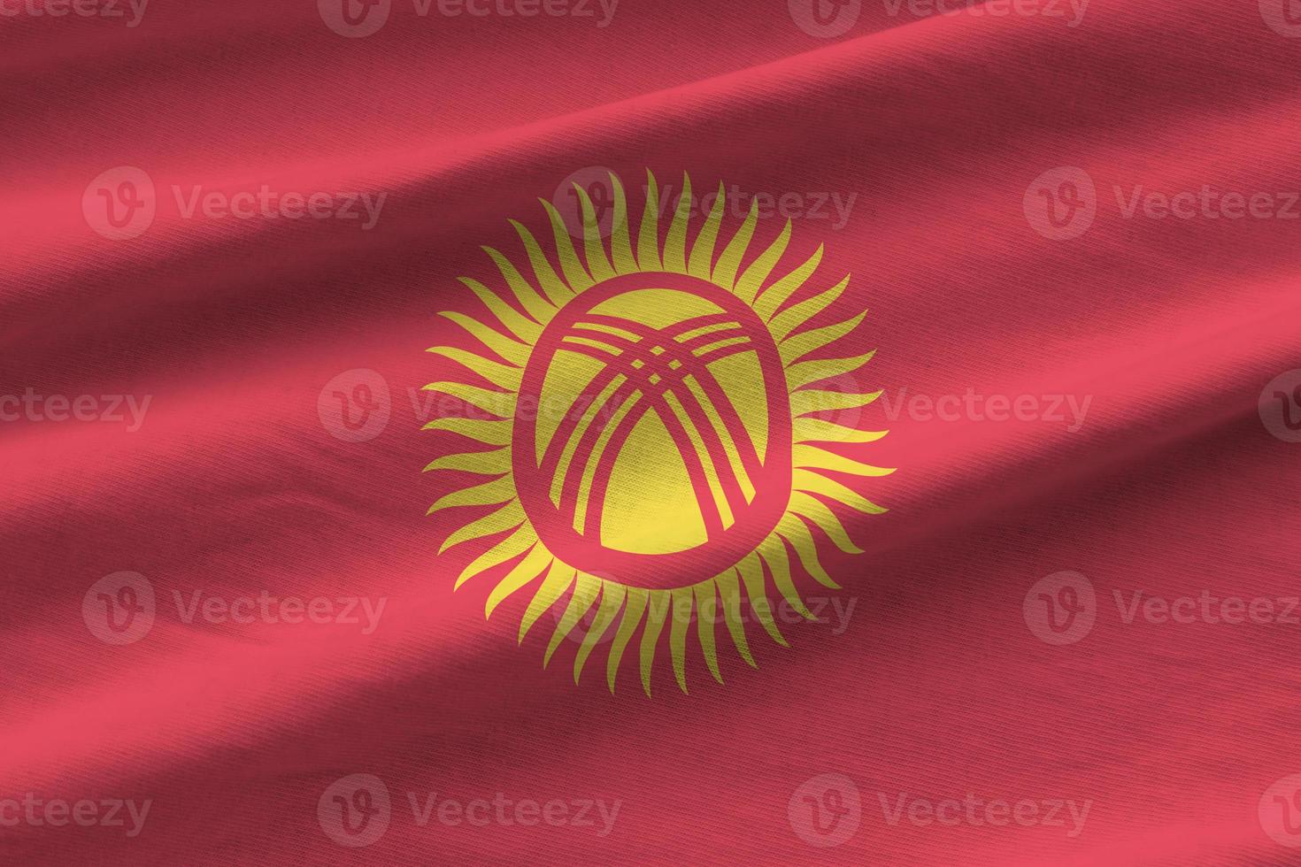 Kyrgyzstan flag with big folds waving close up under the studio light indoors. The official symbols and colors in banner photo