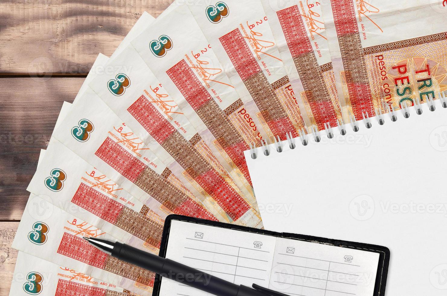 3 cuban pesos convertibles bills fan and notepad with contact book and black pen. Concept of financial planning and business strategy photo