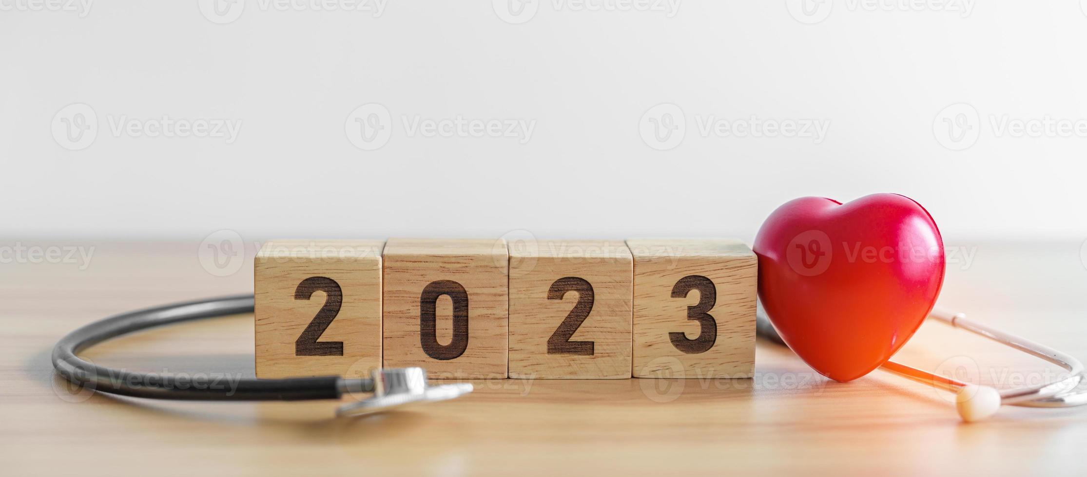 2023 feliz año nuevo para el cuidado de la salud, los seguros, el bienestar y el concepto médico. estetoscopio de médico en la mesa foto